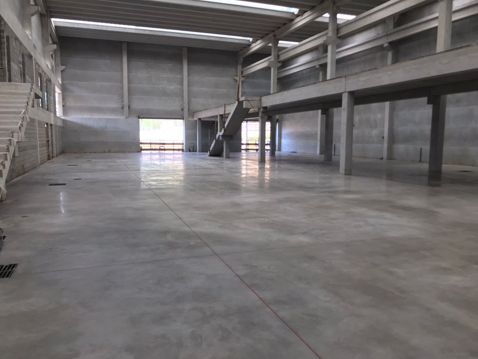 Piso de concreto executado no interior de um galpão industrial.